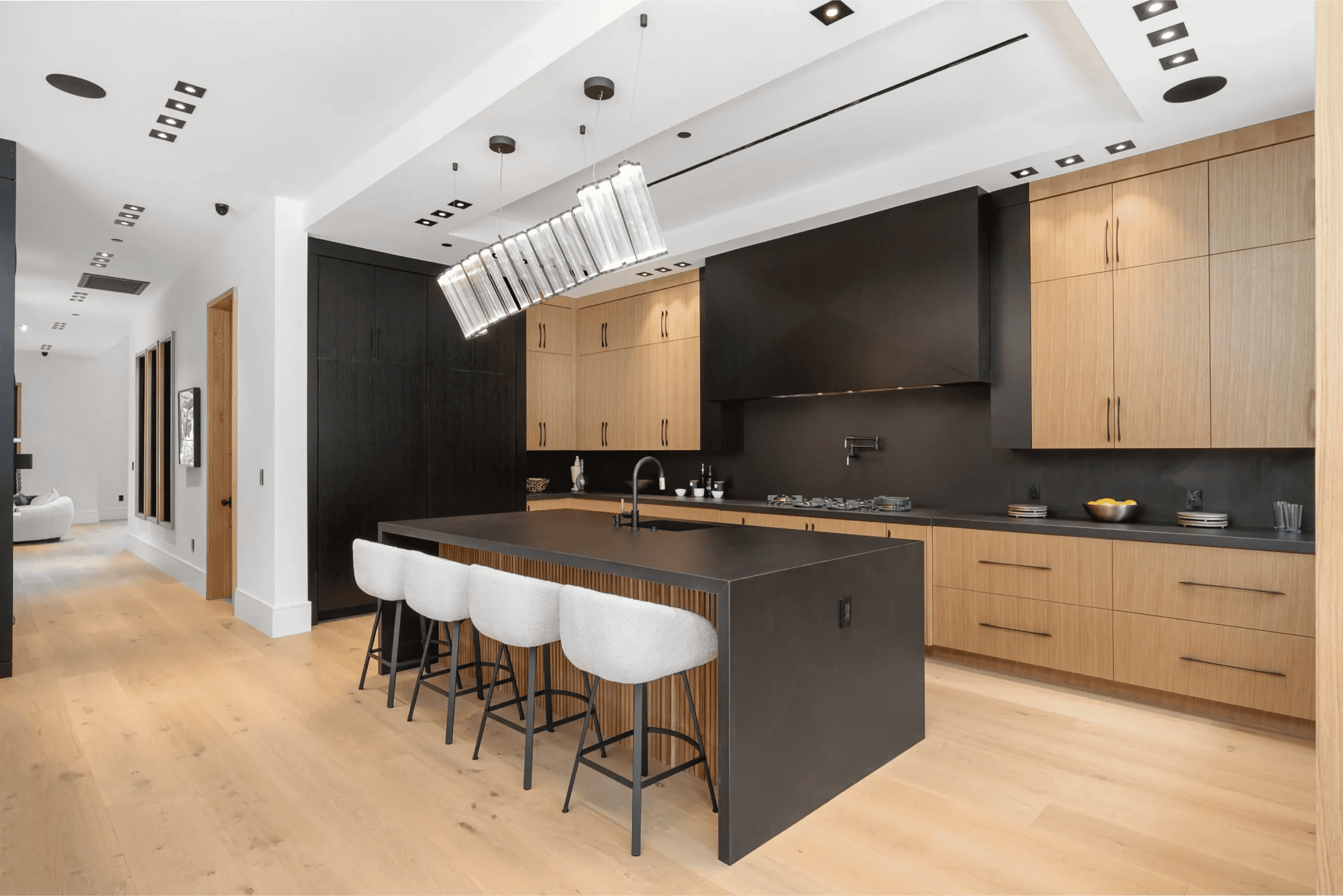 Illuminated luxury kitchen with marble countertops and custom range hood