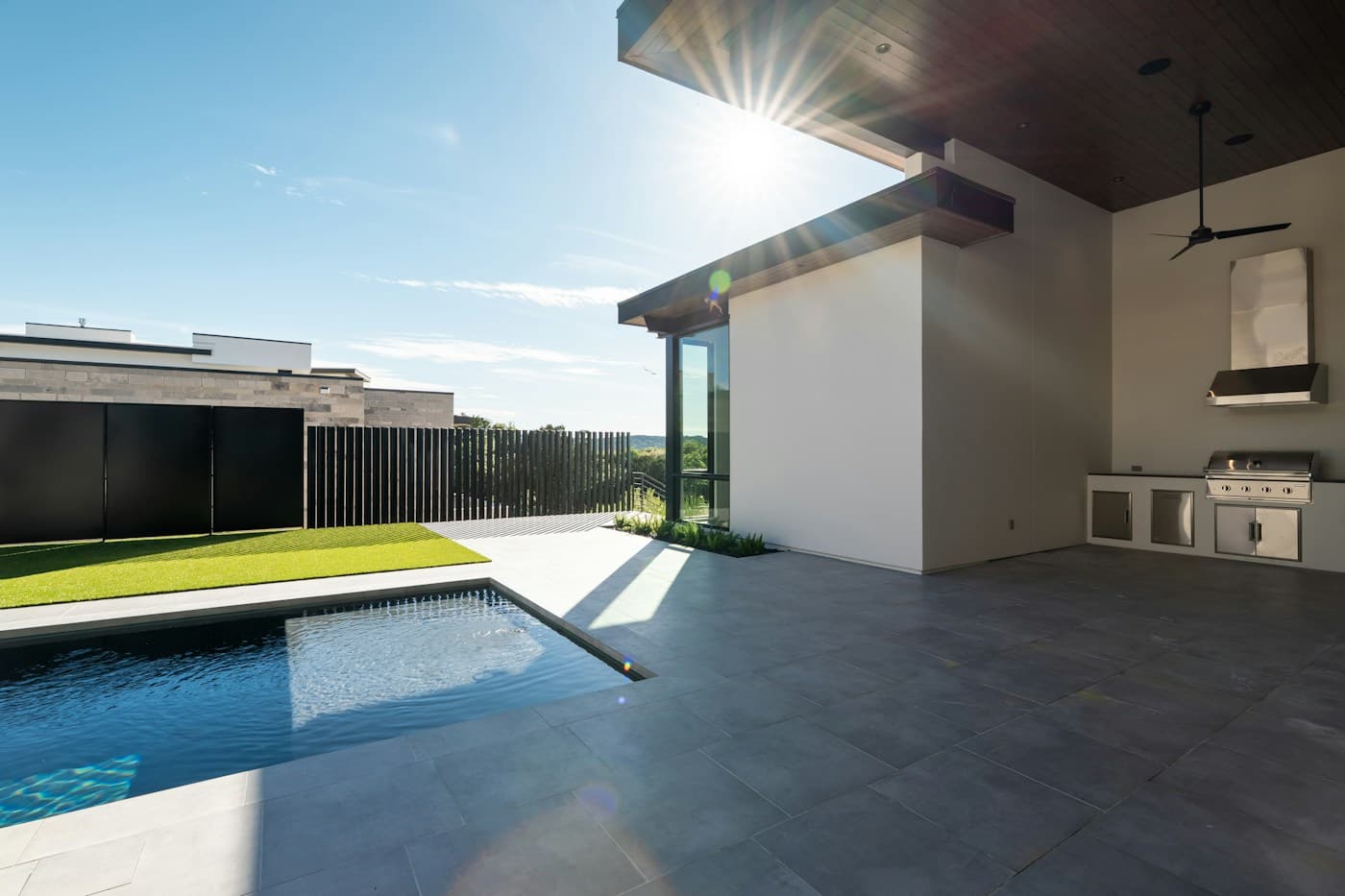 Luxury poolside patio with a modern outdoor kitchen
