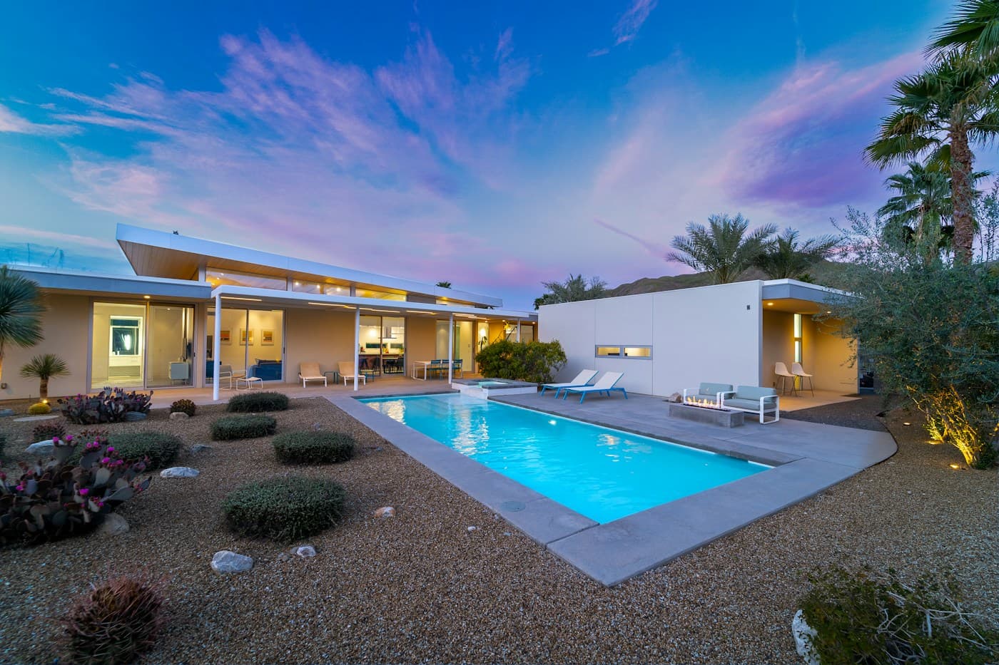 Illuminated contemporary pool and outdoor living area at dusk